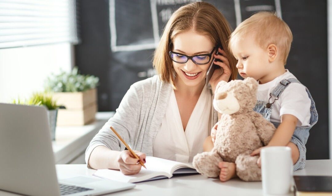 Madre trabajando con su hijo mientras aplica reducción de jornada por cuidado de hijos – SG24 Consultores